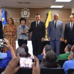 El mpresidente de la JCE, Román Jáquez, entrega la nueva cédula a la titular número 3 millones que renueva su documento de identidad y electoral.