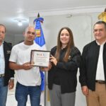 Ciudadano número 4 millones en recibir su nueva cédula de identidad y electoral posa junto al presidente de la JCE con su certificado.